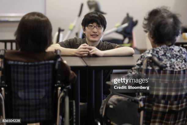 Nursing care worker, center, speaks to residents at the As Partners Co. Asheim Nerima Garden nursing home in Tokyo, Japan, on Friday, Aug. 18, 2017....