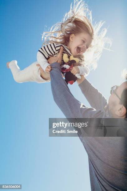 father throwing young daughter in the air - dad throwing kid in air stockfoto's en -beelden