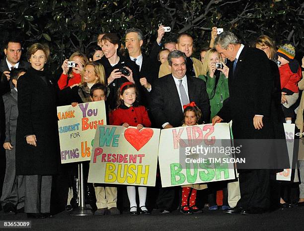 President George W. Bush with First Lady Laura Bush arrive back at the White House via Marine One and visit children holding welcoming signs November...