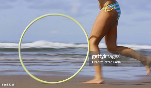running on beach with hula hoop - hoop rolling stock pictures, royalty-free photos & images