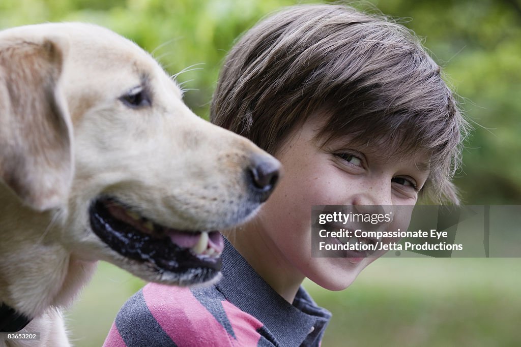 Portrait of a boy with his dog in foreground