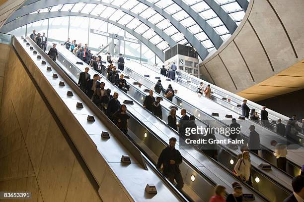commuters using escalator getting to subway - canary wharf stock pictures, royalty-free photos & images