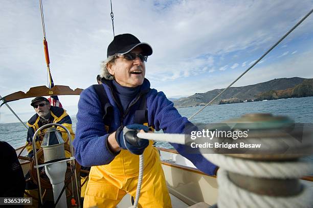 a man trims the sails on his yacht. - male sailing stockfoto's en -beelden
