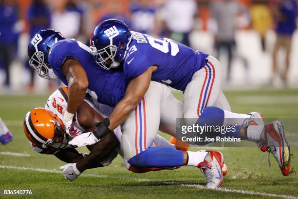 Deontae Skinner and B.J. Goodson of the New York Giants tackle Randall Telfer of the Cleveland Browns in the first half of a preseason game at...
