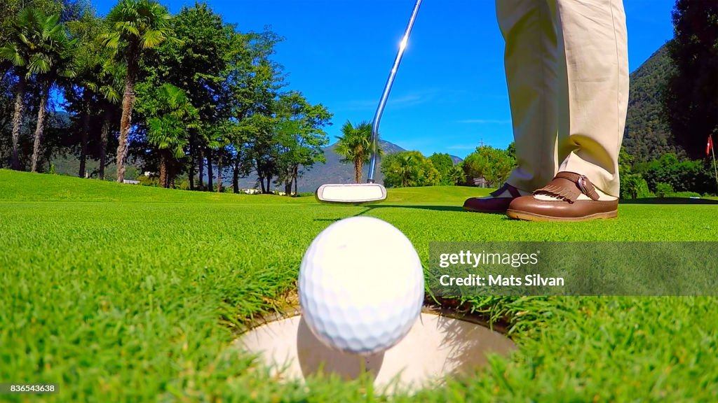 Woman Putting her Golf Ball in the Hole