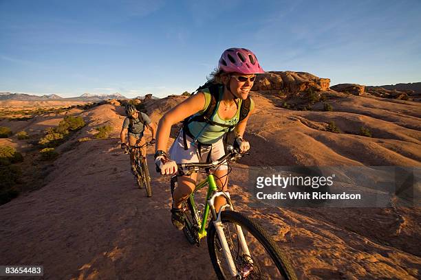 couple mountain biking, moab, utah - moab utah stockfoto's en -beelden