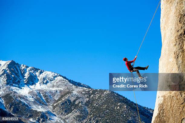 climber rappelling down boulder - rappelling stock pictures, royalty-free photos & images