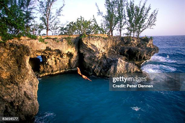 man diving off cliff. - negril jamaica imagens e fotografias de stock