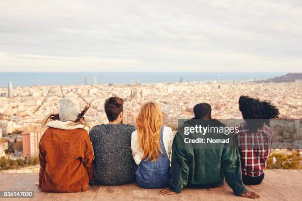 amigos buscando en la ciudad mientras está sentado en la terraza - barcelona españa fotografías e imágenes de stock