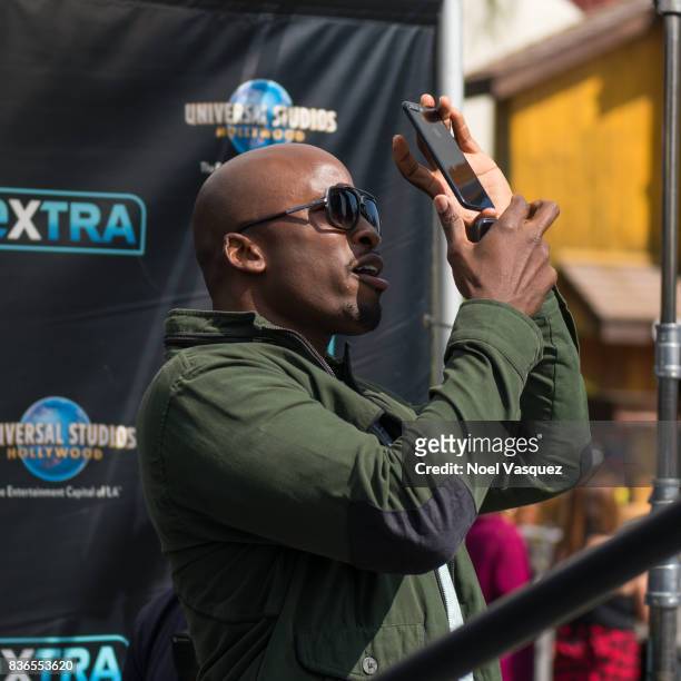 Akbar Gbaja-Biamila attempts to capture a solar eclipse at "Extra" at Universal Studios Hollywood on August 21, 2017 in Universal City, California.