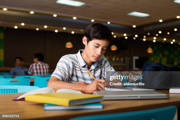 Male student sitting and writing