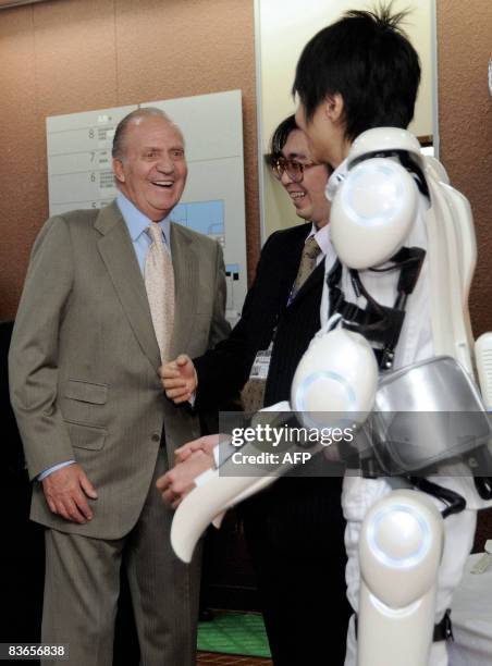 Spanish King Juan Carlos talks with Takeru Sakurai wearing a HAL robot suit, and Professor Yoshiyuki Sankai after a demonstration of the suit at the...