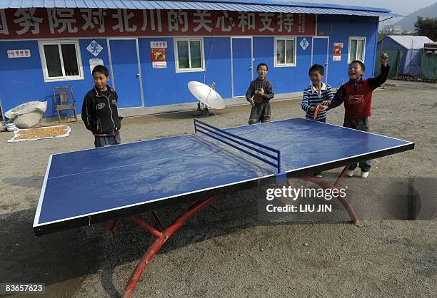 Children play the table tennis at a tent camp in Leigu township of Beichuan county, in China's southwestern province of Sichuan on November 10, 2008....