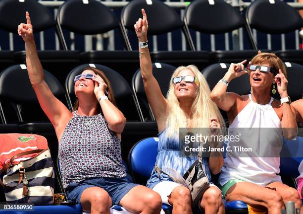 Fans watch the solar eclipse during the third day of the Winston-Salem Open at Wake Forest University on August 21, 2017 in Winston Salem, North...