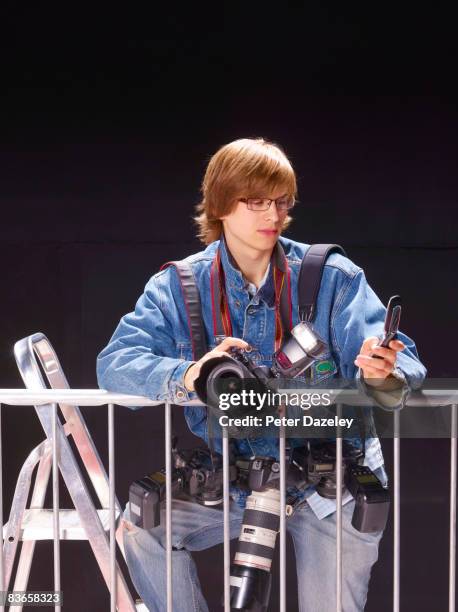 paparazzi texting on mobile-phone at barrier - telelens stockfoto's en -beelden