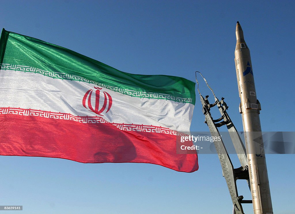 An Iranian flag flutters next to a groun