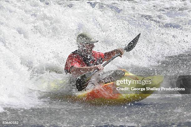 kayaker paddling through river rapids - canoeing and kayaking stock pictures, royalty-free photos & images