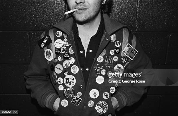 Punk music fan sporting his favorite bands in an array of buttons on his coat poses during a 1979 Los Angeles, California, portrait session in the...