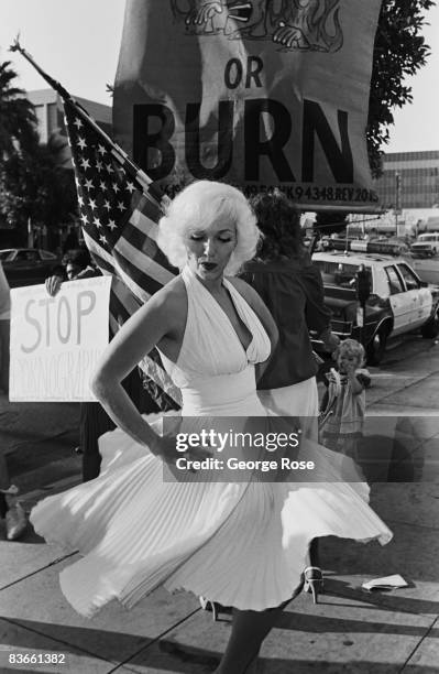 Marilyn Monroe look-alike entertains a crowd of onlookers and protesters outside the 1980 Hollywood, California, Adult Entertainment Awards held at...