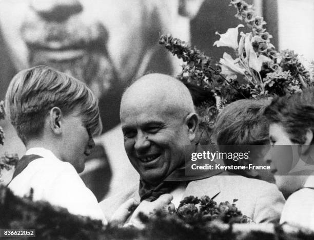 Nikita Khrouchtchev reçoit de la part d'un jeune Allemand un foulard rouge lors de sa visite à Halle, Allemagne en juillet 1958.