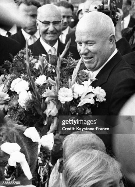 Son arrivée, Nikita Khrouchtchev reçoit des mains d'enfants un bouquet de fleurs, à Helsinki, Finlande en 1954.
