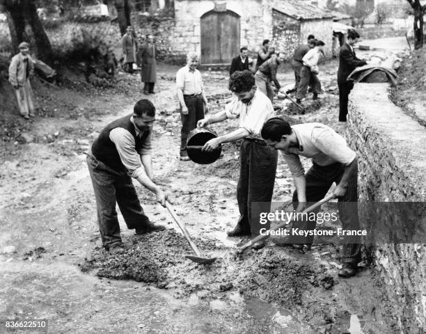 Des villageois grecs, aidés par les provisions américaines de ciment et d'outillage, construisent eux-mêmes la route qui reliera leur village à...