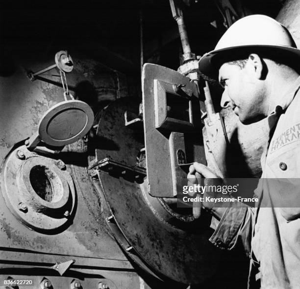 Un ouvrier vérifie le fonctionnement de l'équipement dans une usine de ciment en avril 1966 en Grèce.