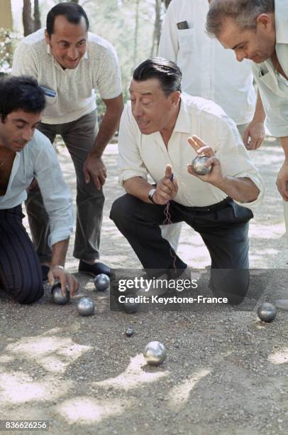 En vacances dans sa propriété de Carry-Le-Rouet, l'acteur français Fernandel joue à la pétanque entouré de quelques amis et de son fils Franck ,...