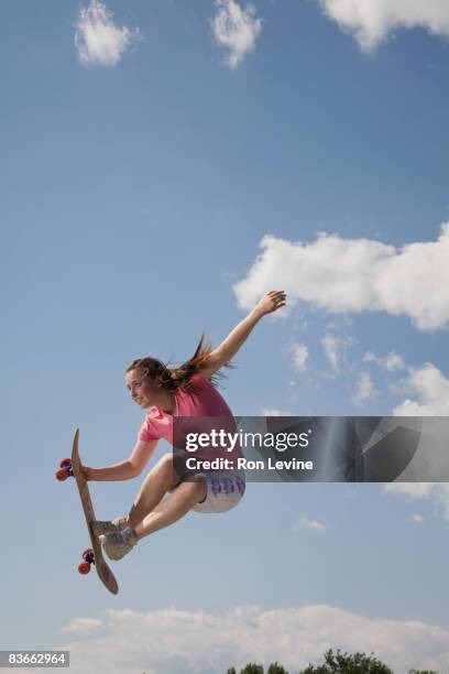 young woman on a skateboard, airborne - skateboard jump stock pictures, royalty-free photos & images