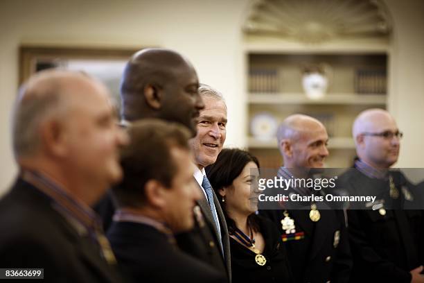President George W. Bush stands alongside recipients of the Public Safety Officer Medal of Valor award in the Oval Office at the White House on...