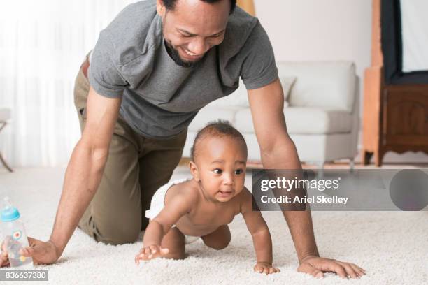 father with crawling baby - leanincollection father photos et images de collection