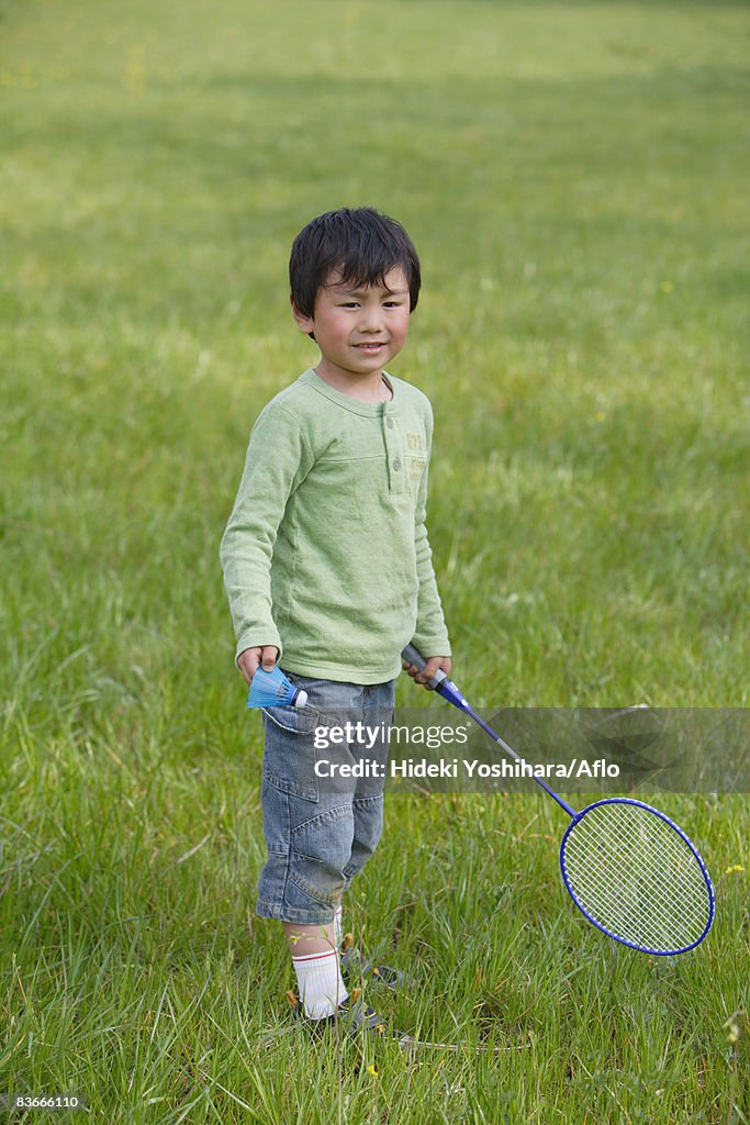 Boy playing badminton in park