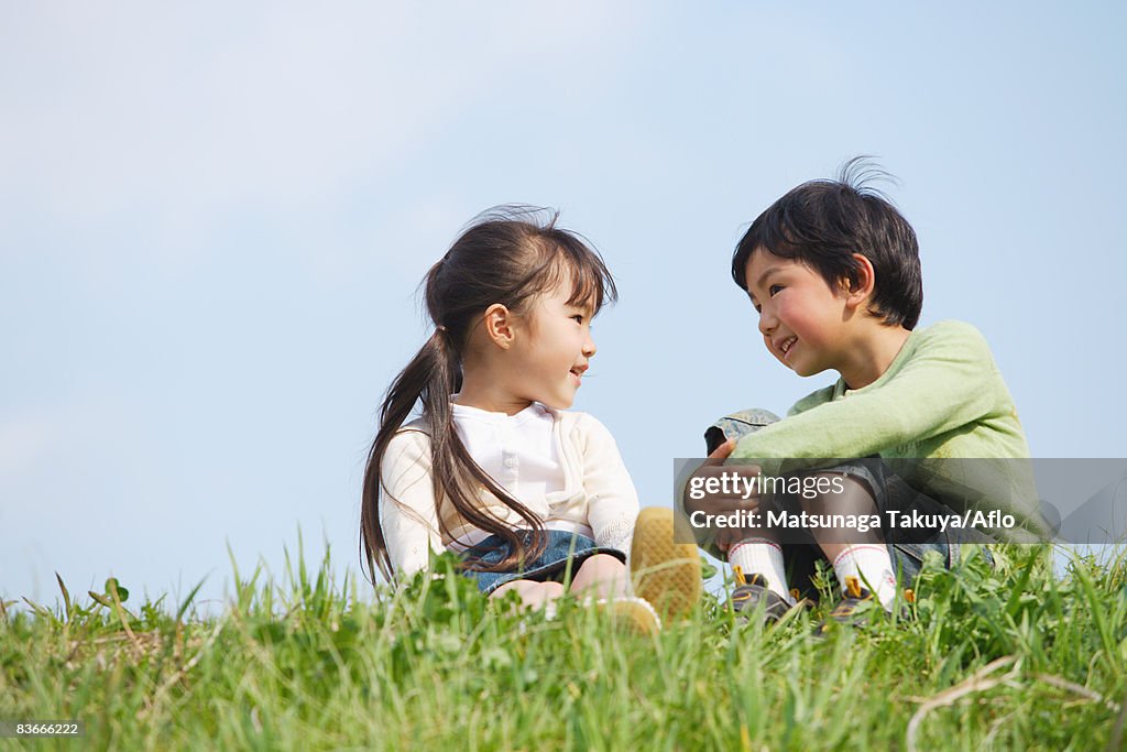 Smiling children sitting in park together