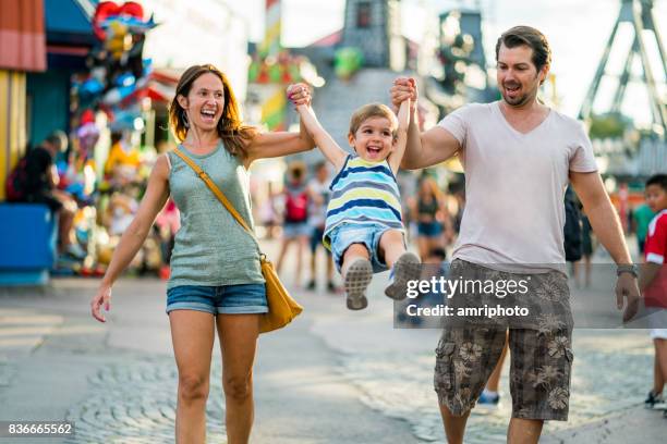 happy family enjoying summer day in amusement park - luna park stock pictures, royalty-free photos & images