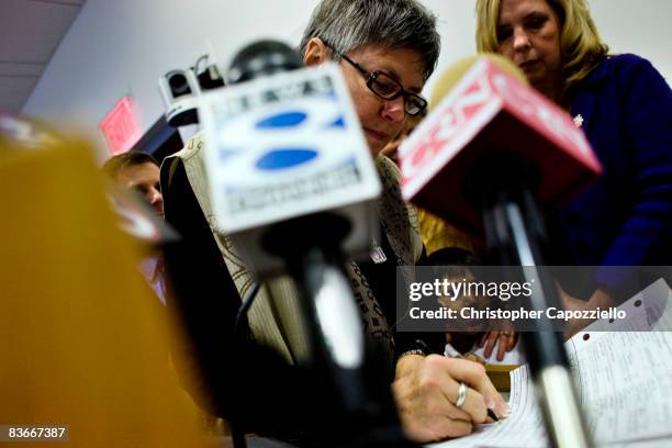 Jody Mock signs her marriage certificate with Beth Kerrigan as Town Clerk Essie Labrot looks on in a room full of supporters and media at West...