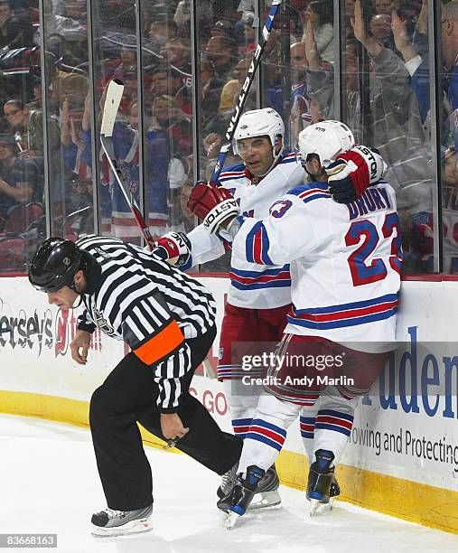 Referee Gord Dwyer escapes a goal celebration by Nigel Dawes and Chris Drury of the New York Rangers during the second period of a contest against...