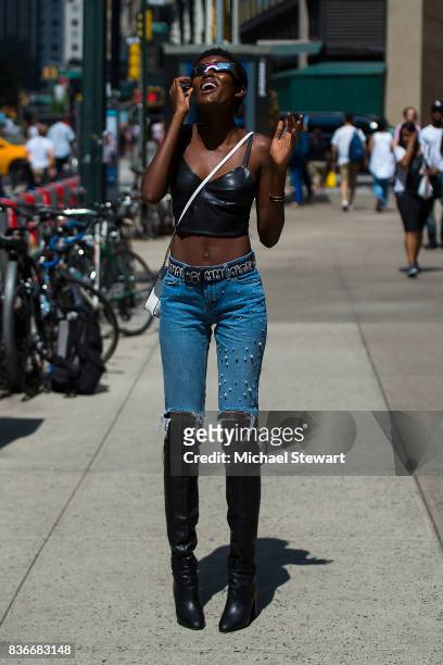 Model Amilna Estevao views the solar eclipse using solar glasses in Midtown on August 21, 2017 in New York, New York.