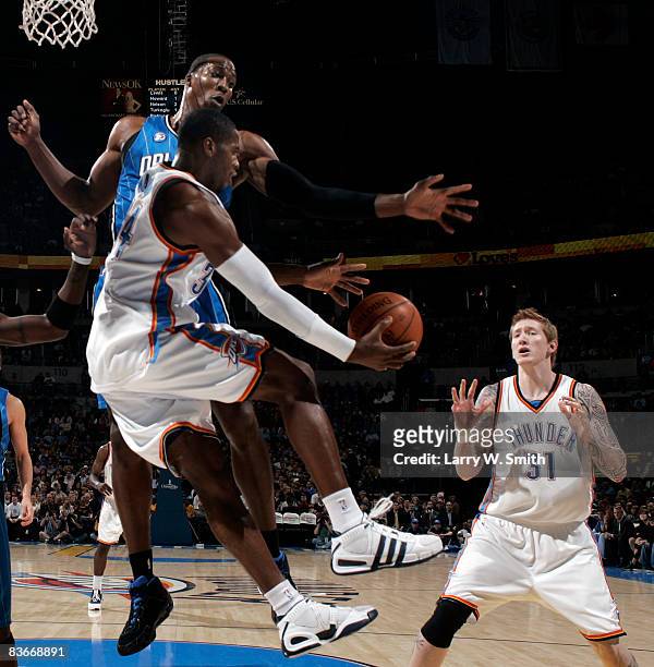 Desmond Mason of the Oklahoma City Thunder tries passing the ball to teammate Robert Swift, while being guarded by Dwight Howard of the Orlando Magic...