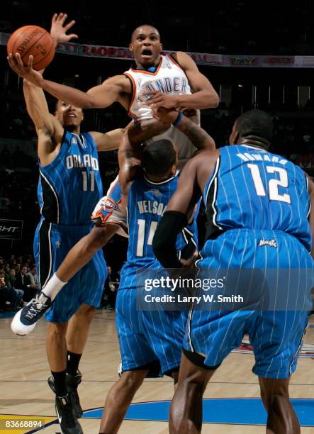 Russell Westbrook of the Oklahoma City Thunder goes up for a layup while being guarded by Jameer Nelson, Courtney Lee and Dwight Howard of the...