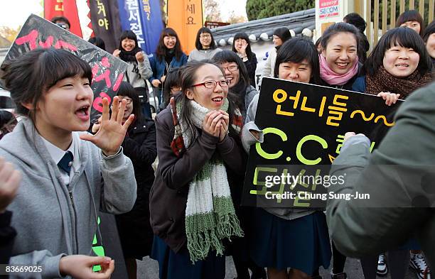 South Korean high school girls cheer on their senior schoolmates taking the College Scholastic Ability Test at a school on November 13, 2008 in...