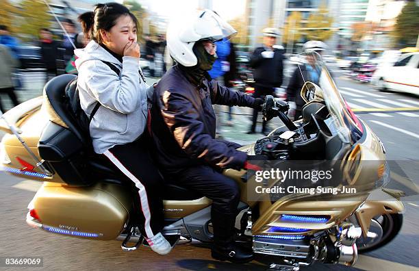 South Korean high school girl arrives at a school by police bike to take the College Scholastic Ability Test on November 13, 2008 in Seoul, South...