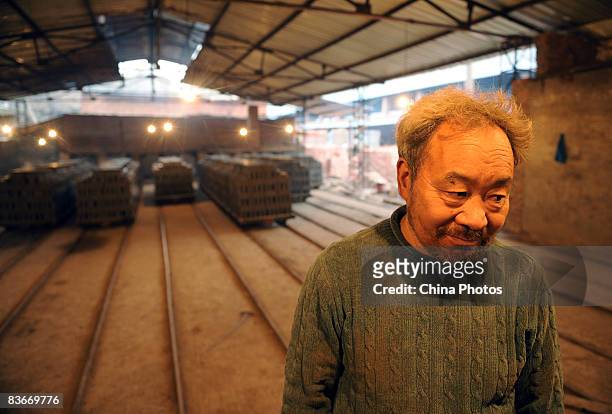 Worker works overtime in a brick factory to produce bricks for the rebuilding of houses for Sichuan Earthquake survivers on November 12, 2008 in...
