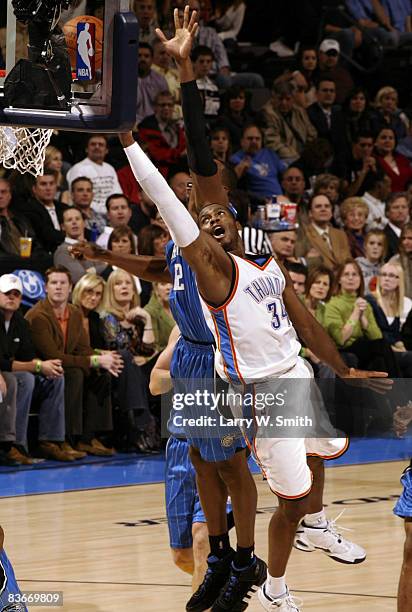 Desmond Mason of the Oklahoma City Thunder lays the ball up while being guarded by Dwight Howard of the Orlando Magic at the Ford Center November 12,...