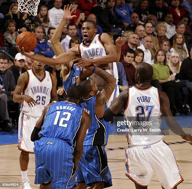 Russell Westbrook of the Oklahoma City Thunder goes to the basket against Jameer Nelson and Dwight Howard of the Orlando Magic at the Ford Center...