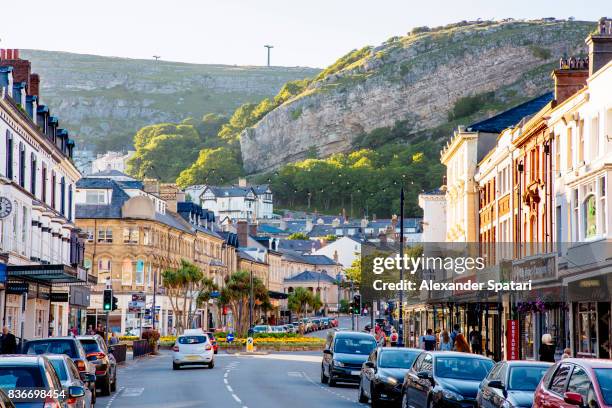 mainstreet in llandudno town with great orme head cliff in the background - llandudno wales stock pictures, royalty-free photos & images