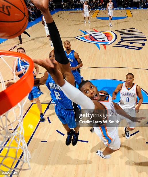 Desmond Mason of the Oklahoma City Thunder lays the ball up while being guarded by Dwight Howard of the Orlando Magic at the Ford Center November 12,...