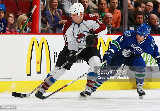 Ryan Johnson of the Vancouver Canucks checks Cody McCormick of the Colorado Avalanche during their game at General Motors Place November 12, 2008 in...
