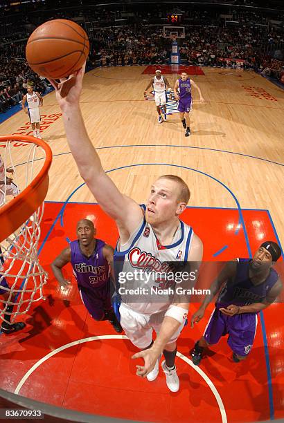 Chris Kaman of the Los Angeles Clippers puts up a shot while Bobby Jackson and John Salmons of the Sacramento Kings look on during their game at...