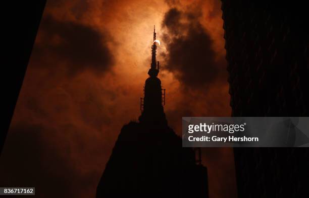 The sun is eclipsed by the moon over top of the Empire State Building in New York City on August 21, 2017.