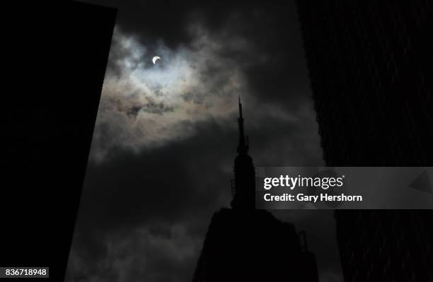 The sun is eclipsed by the moon over top of the Empire State Building in New York City on August 21, 2017.